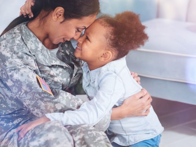 Military mother and daughter embracing