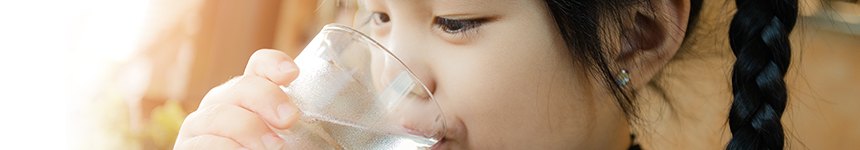 Young girl drinking water from glass
